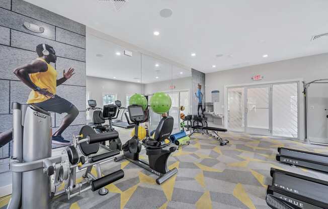 a gym with cardio equipment and a man running on a treadmill