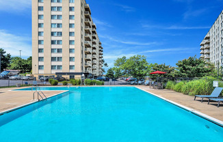 a swimming pool with an apartment building in the background