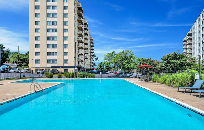 a swimming pool with an apartment building in the background