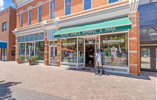 A storefront with a green awning that sells retro sports apparel.