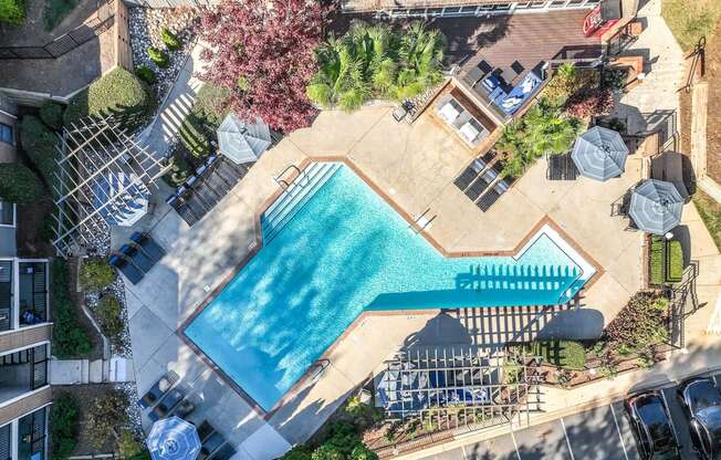 an aerial view of a swimming pool in a backyard with umbrellas