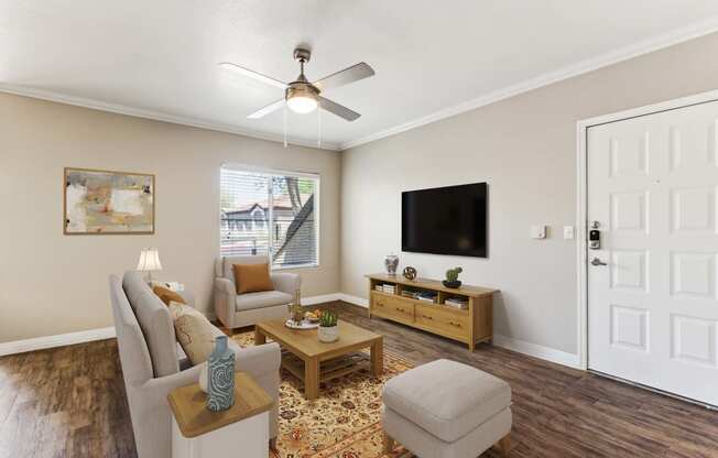 an open living room with a ceiling fan and a tv
