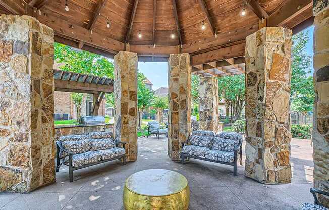 Stone pillars support a roof over a seating area.