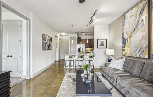 Open living space with a view into the kitchen at Allusion at West University apartments in Houston, TX