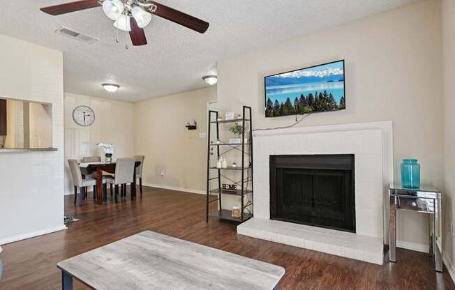 A living room with a fireplace and a television mounted above it.
