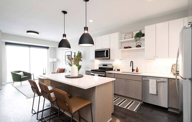 a kitchen with a center island next to a stove top oven at The Bohen Luxury Apartments for Rent Minneapolis