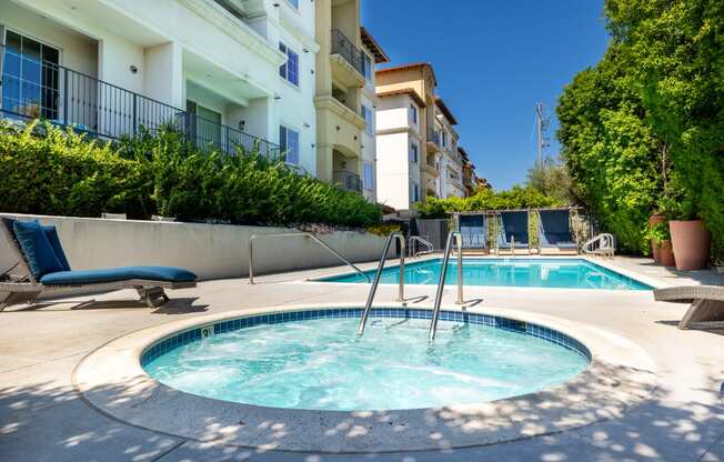 a hot tub and a pool with buildings in the background