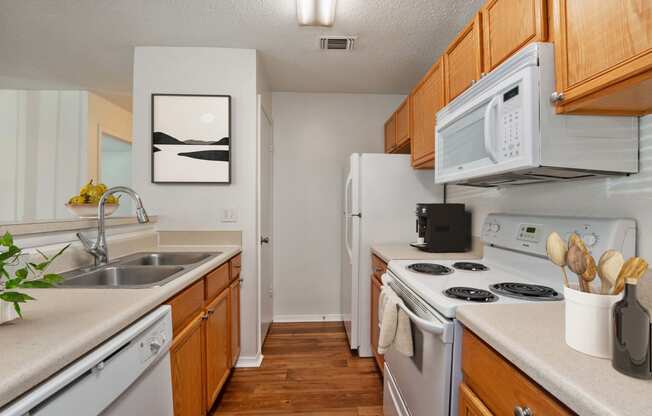 a kitchen with white appliances and wooden cabinets