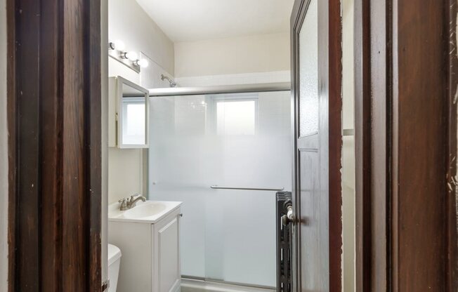 a white bathroom with a shower and a sink