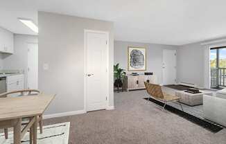 Model Living Room with Carpet and Patio Accessibility at Stone Ends Apartments in Stoughton, MA.