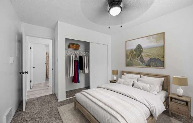 A bedroom with a large bed and a painting on the wall.
