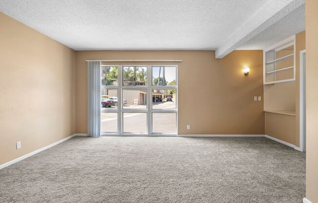 an empty living room with a sliding glass door and a bookshelf