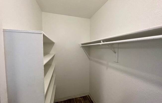 A white closet with shelves and a door.