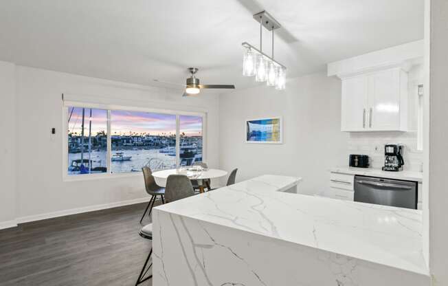 a kitchen with a marble counter top and a table with chairs