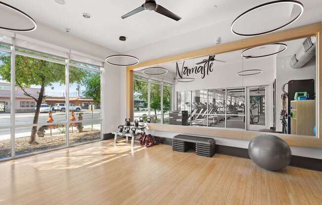 A gym with a wooden floor and a mirror on the wall.