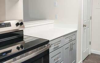 A modern kitchen with a stove top oven and a counter top.