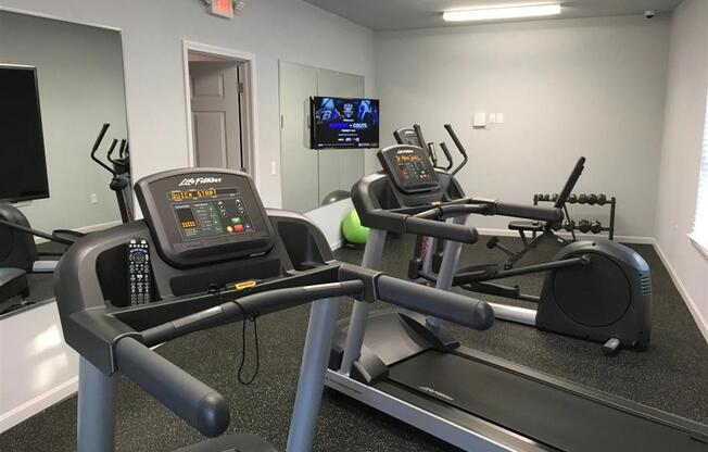 the gym in our new building is equipped with a treadmill and a tv