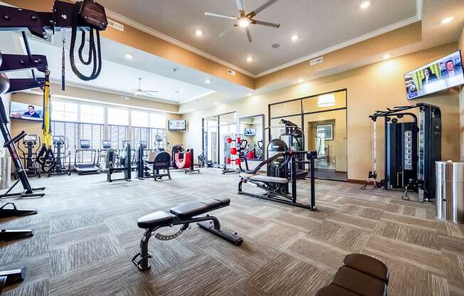 a gym with a lot of equipment and a large window