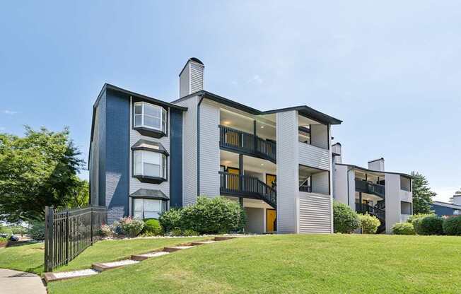 A modern apartment building with a black fence in front.