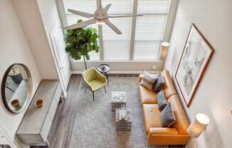 an overhead view of a living room with a brown couch and yellow chair at Metro 303, Hempstead, NY