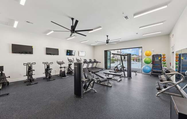 a gym with treadmills and other exercise equipment in a building with a window