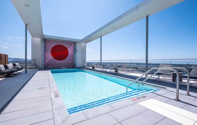 A swimming pool on a rooftop with a red circle on the wall.