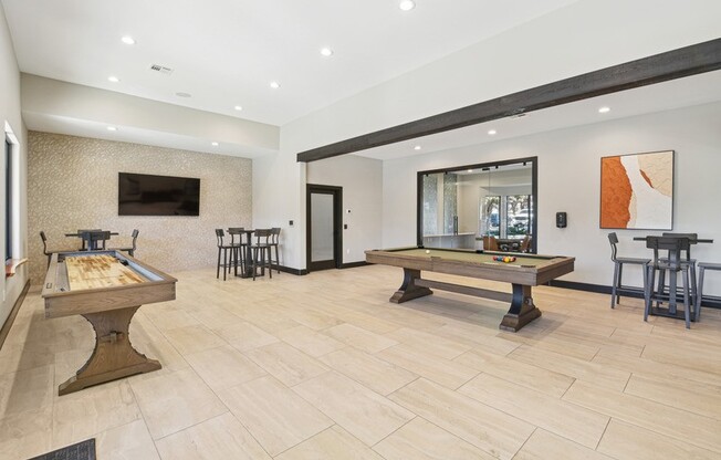 the game room with two pool tables and a television