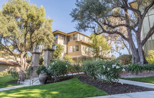 a house with a lawn and trees in front of it