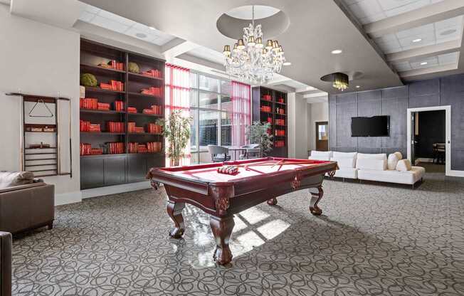 A pool table is in the middle of a room with a grey carpet.