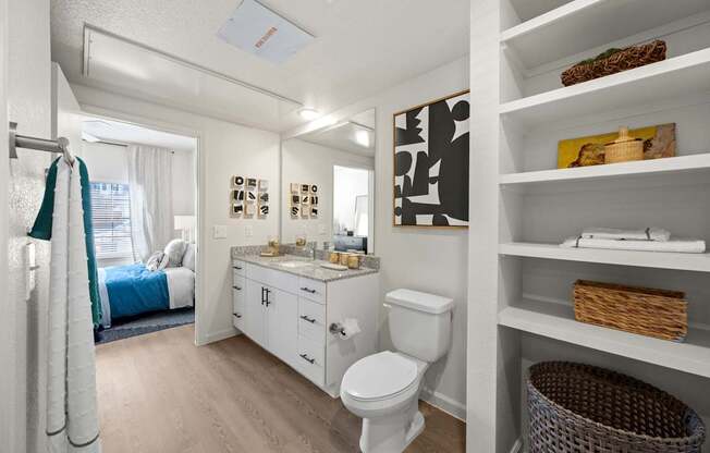 A white bathroom with a toilet, sink, and shelves. at Bridge at Tech Crossing, Texas, 78753