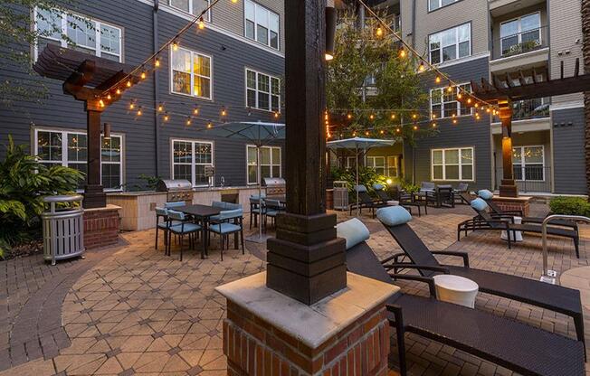 a courtyard with patio furniture and string lights