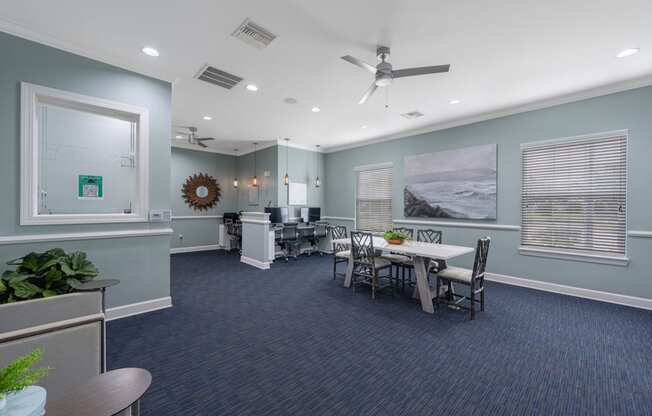 a conference room with a table and chairs and a ceiling fan
