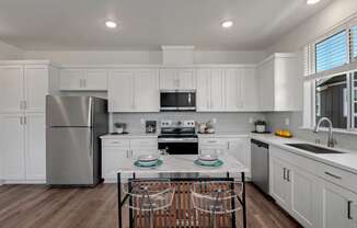a kitchen with white cabinets and stainless steel appliances