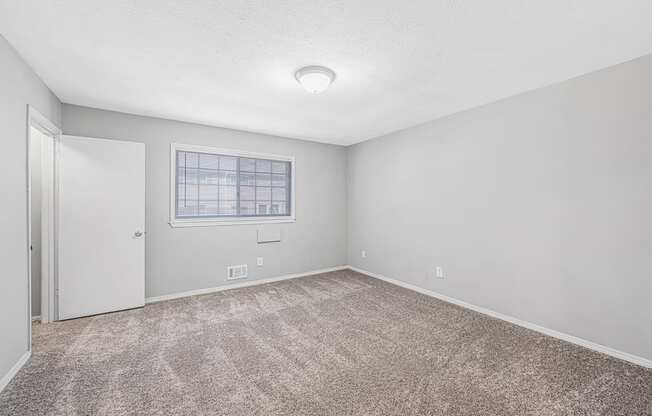 an empty room with carpet and a window