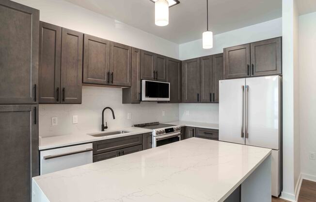 a kitchen with a white counter top and a refrigerator