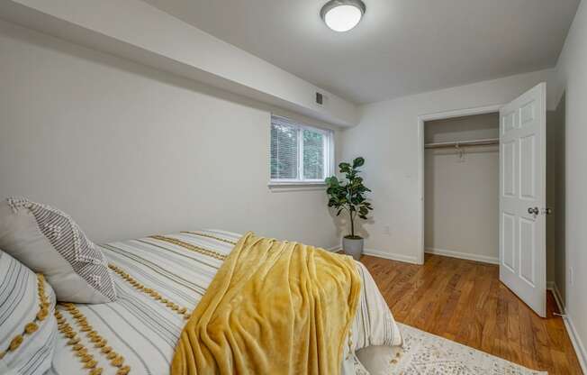 a bedroom with a bed and a yellow blanket