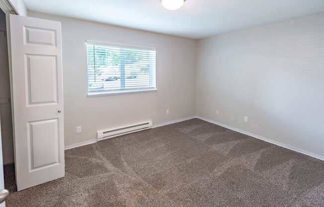 a bedroom with carpet and a window