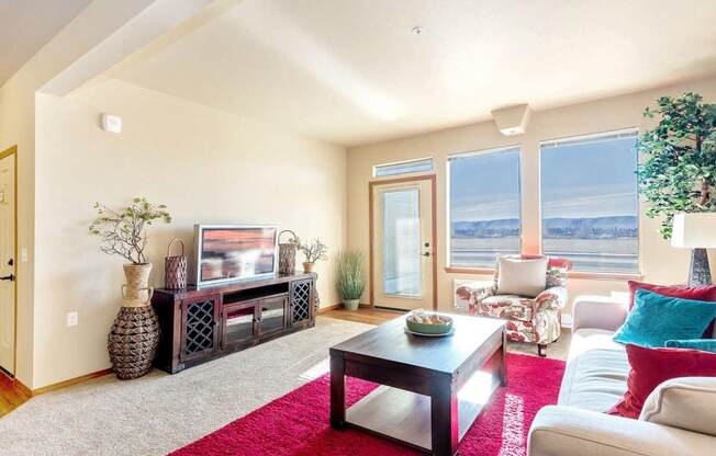 a living room with a couch and a tv in front of a window