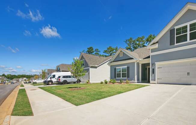 a house with a driveway and a lawn in front of it
