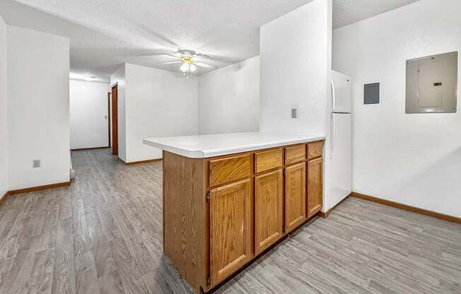 A kitchen area with a wooden island and a refrigerator.