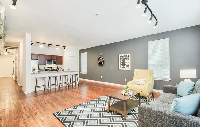 a spacious living room with a kitchen in the background