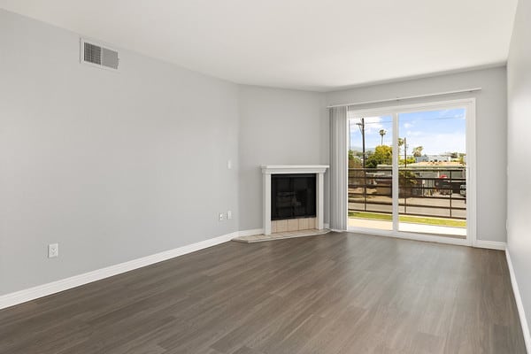 an empty living room with a fireplace and a sliding glass door at NOHO GALLERY Apartments, California, 91601