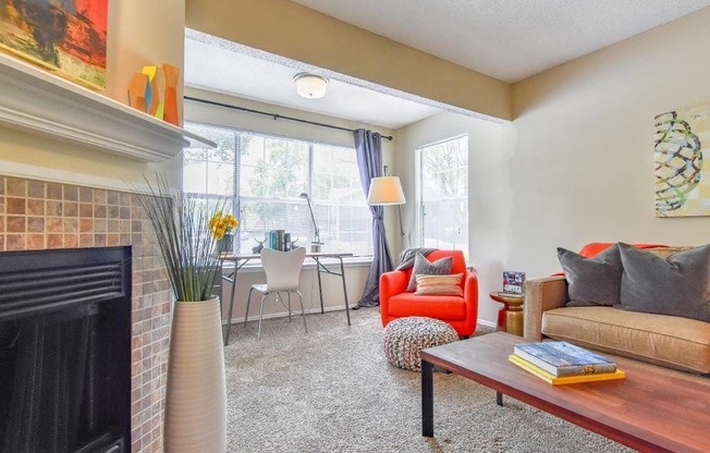 A living room with a fireplace, chairs, and a couch.