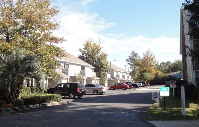 a street with houses on either side and cars parked on the side of the road