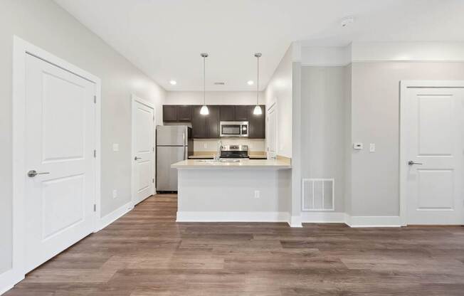 A kitchen with white cabinets and a wooden floor.