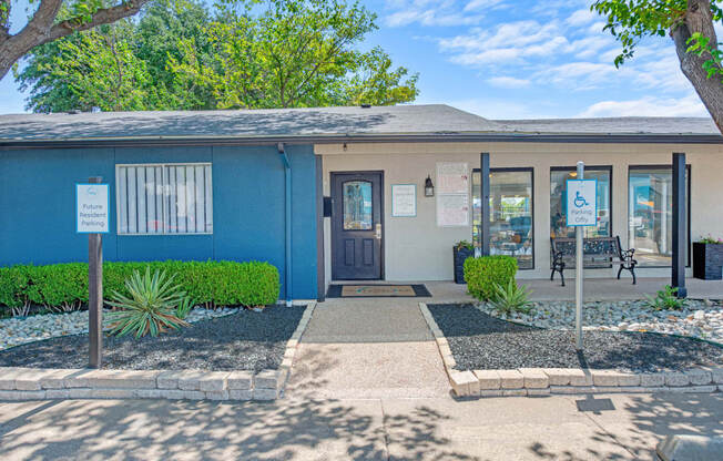 a blue building with a blue door and a sidewalk in front of it