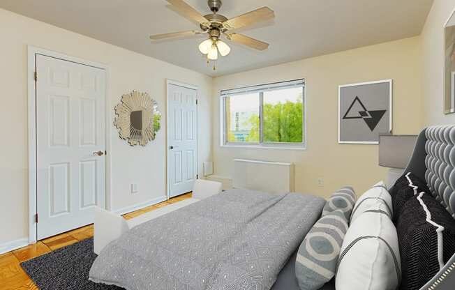 a bedroom with a bed, 2 closets, ceiling fan and window at chillum place apartments in washington dc