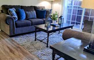 A living room with a blue couch and a coffee table.