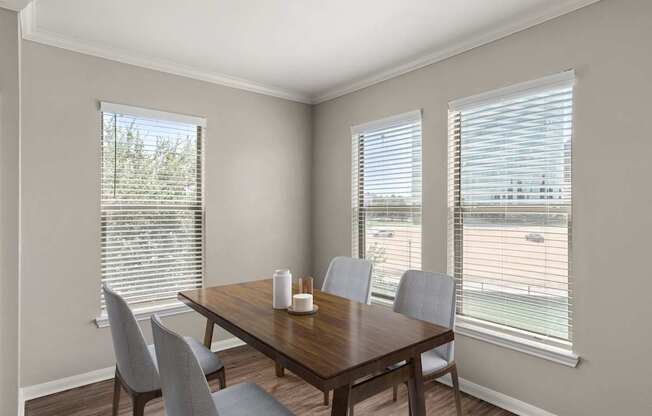 A dining room with a wooden table and chairs.