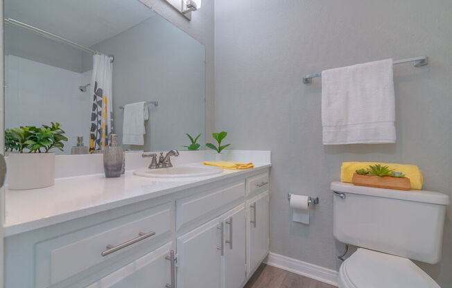 a white bathroom with a toilet sink and mirror at Citra Apartments LLC, San Diego, California